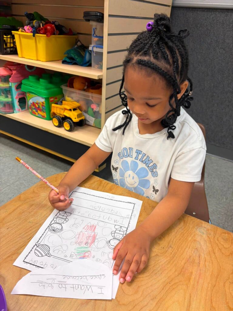 A child doing school work at Creative Childcare Academy and Camp in Fredericksburg
