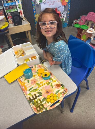 A little girl with a bee tray at Creative Childcare Academy and Camp