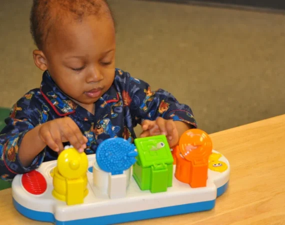 A boy enjoying a musical instrument at Creative Childcare Academy and Camp