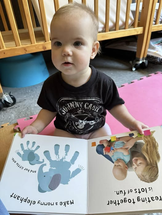 An infant reading a book at CCC